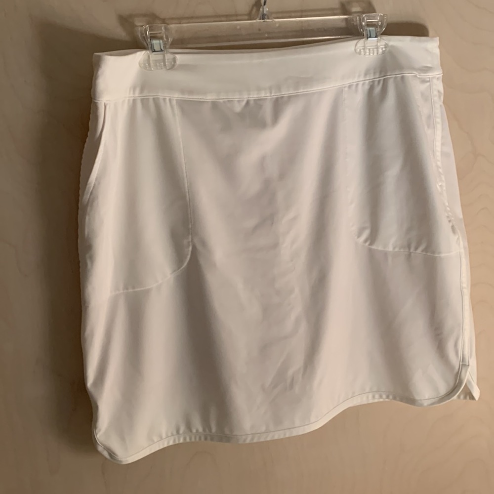 Ivory golf skort.  Two front pockets and one back zip pocket.